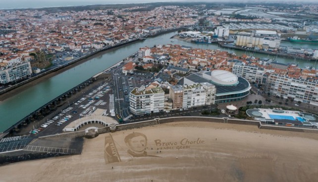 Гигантский портрет Шарли Далена на городском пляже накануне прибытия гонщика