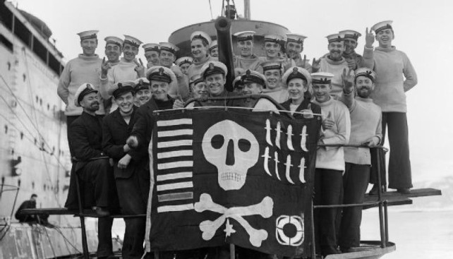Команда субмарины Utmost с «Веселым Роджером», февраль 1942 года. Флаг указывает на потопление 9 судов, участие в 8 разведывательных операциях и одной спасательной